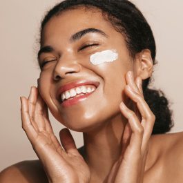 Femme appliquant un soin hydratant pour conserver son bronzage après l’été grâce à l’exfoliation, l’hydratation et la réparation de la peau.