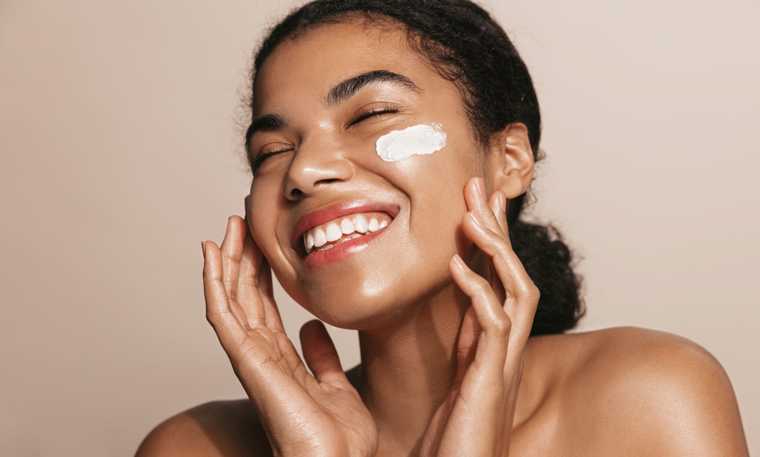 Femme appliquant un soin hydratant pour conserver son bronzage après l’été grâce à l’exfoliation, l’hydratation et la réparation de la peau.