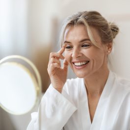 Femme appliquant un soin visage anti-âge dans une ambiance automnale