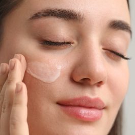 Femme appliquant une crème hydratante sur son visage en hiver