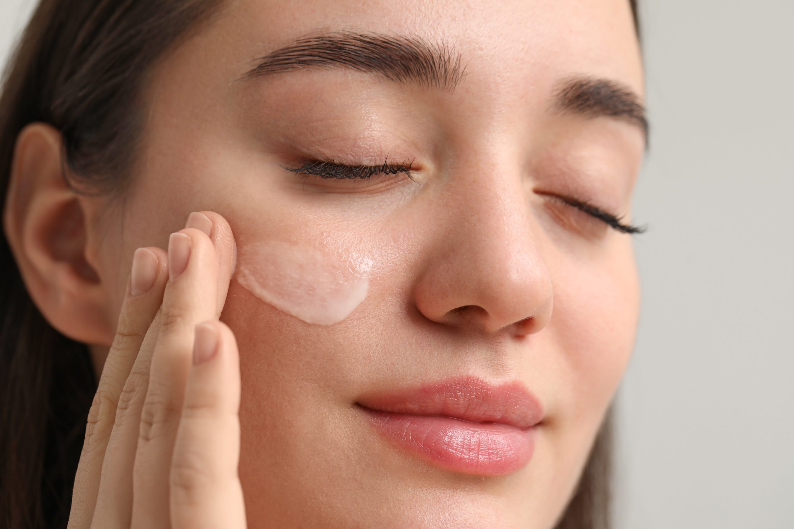 Femme appliquant une crème hydratante sur son visage en hiver