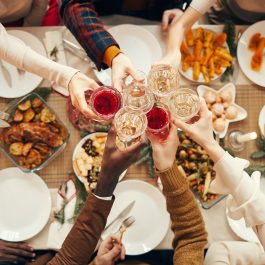Groupe de personnes trinquant autour d’un repas de fête