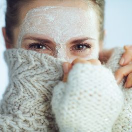 Femme avec un masque visage et pull en laine, protection contre le froid hivernal