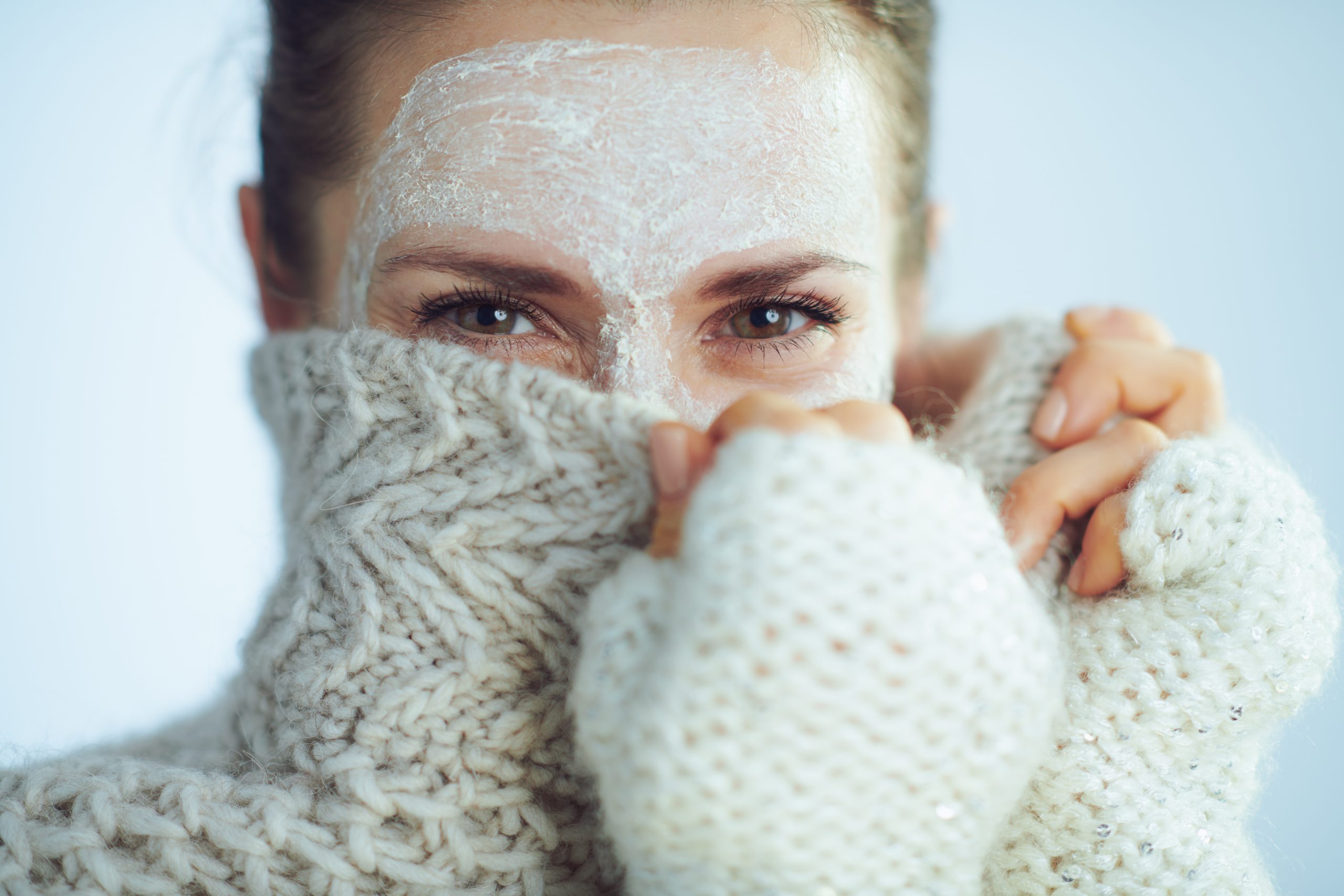 Femme avec un masque visage et pull en laine, protection contre le froid hivernal