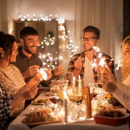 Groupe d’amis partageant un repas de fêtes dans une ambiance chaleureuse, symbole de convivialité