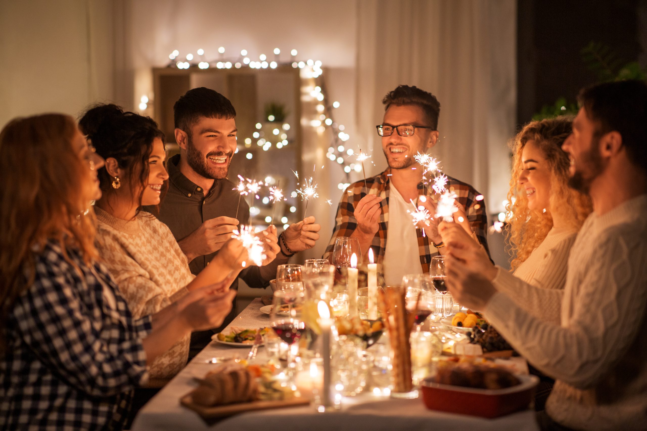 Groupe d’amis partageant un repas de fêtes dans une ambiance chaleureuse, symbole de convivialité