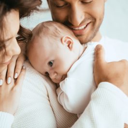 Bébé endormi dans les bras d’un parent – charge mentale parentale