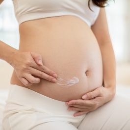Application de crème sur le ventre post-accouchement pour prévenir les vergetures